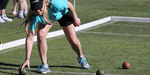 Volunteer helping to assist picking up balls at Special Olympic Event