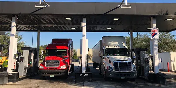 Cardlock site image showcasing RFID scanning devices above truck bays. Bays are occupied by two commercial trucks.